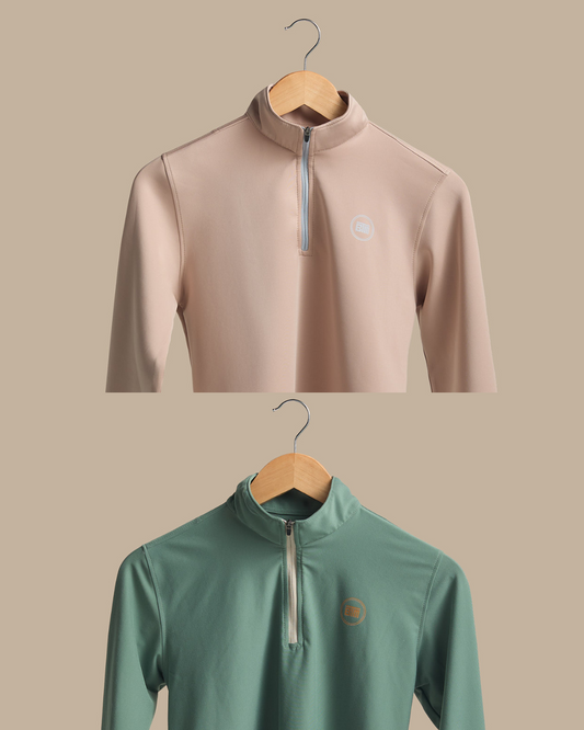 Two long-sleeve shirts on hangers against a beige background